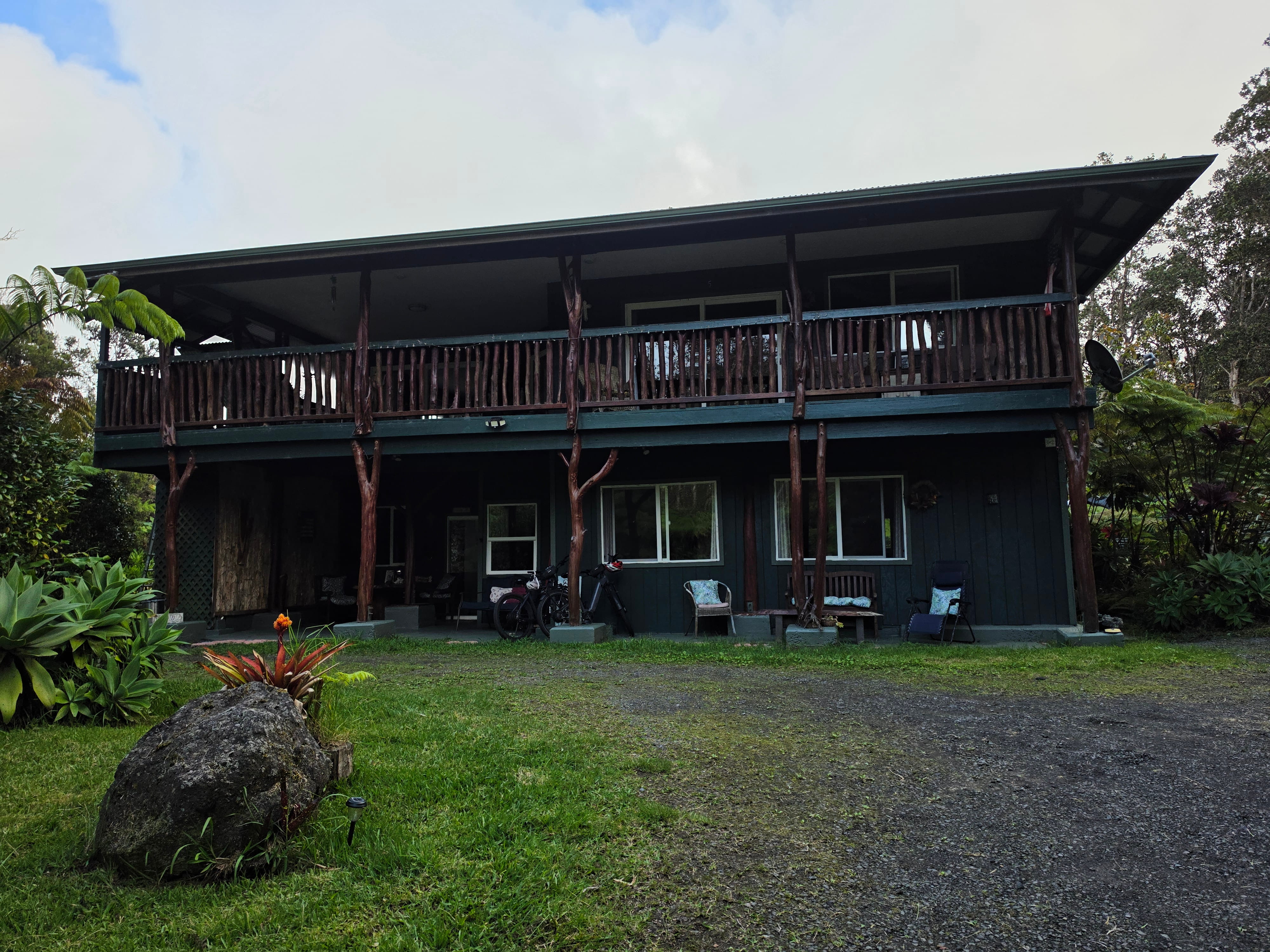 Front exterior of Aloha Crater Lodge showing the ground level parking and basecamp e-bike rental fleet